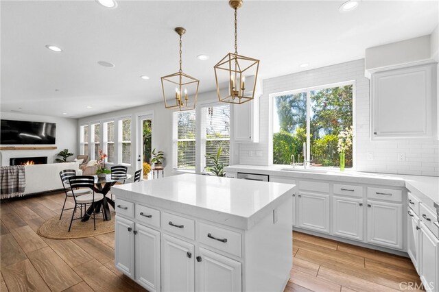 106 Via Sabinas, San Clemente, CA 92673 - kitchen featuring a sink, recessed lighting, a warm lit fireplace, healthy amount of natural light, and light wood-style flooring