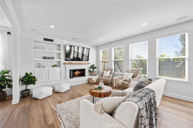 106 Via Sabinas, San Clemente, CA 92673 - living area with wood finished floors, baseboards, a lit fireplace, recessed lighting, and built in shelves