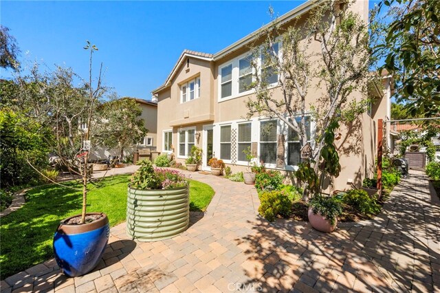 106 Via Sabinas, San Clemente, CA 92673 - back of property with stucco siding, a patio area, and a lawn