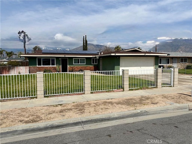 single story home featuring a fenced front yard, a front yard, a garage, brick siding, and solar panels