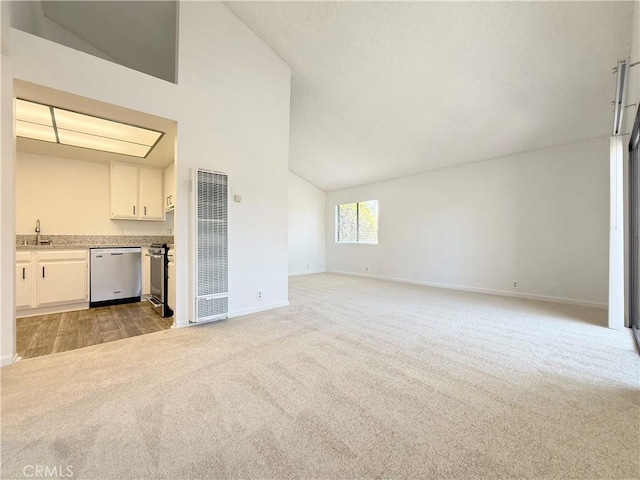 unfurnished living room featuring high vaulted ceiling, baseboards, a sink, and light colored carpet