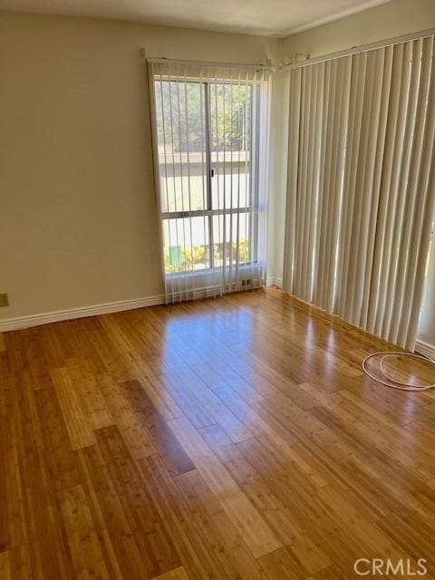 empty room with baseboards and wood finished floors