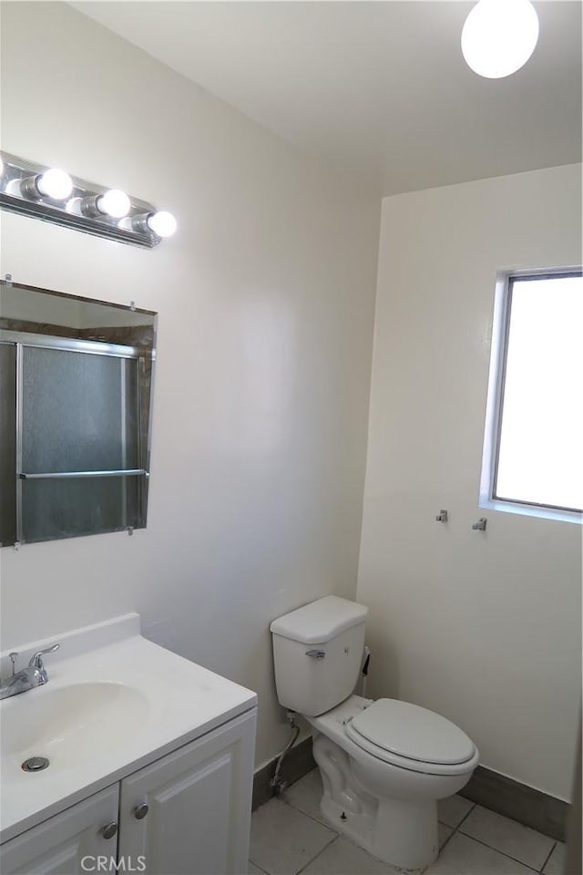 bathroom with toilet, vanity, an enclosed shower, and tile patterned floors