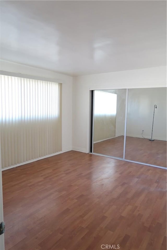 unfurnished bedroom with a closet and wood finished floors