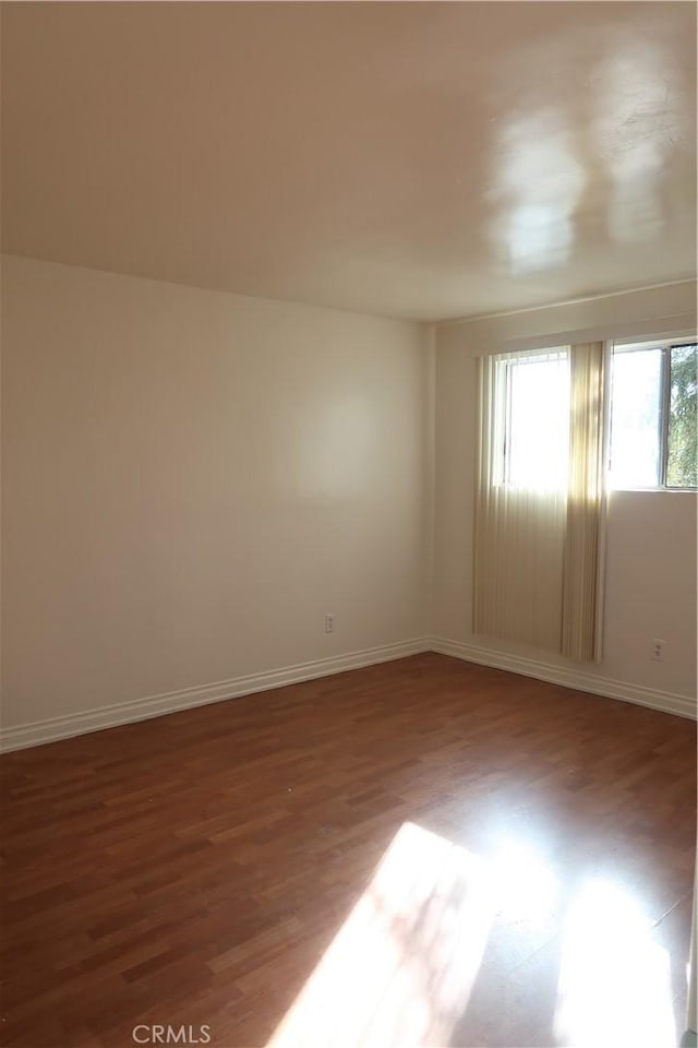 unfurnished room featuring wood finished floors and baseboards