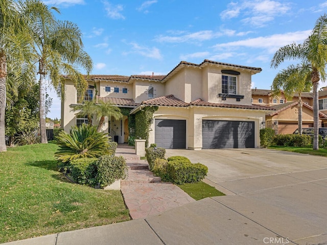 mediterranean / spanish home with a tile roof, stucco siding, concrete driveway, an attached garage, and a front lawn