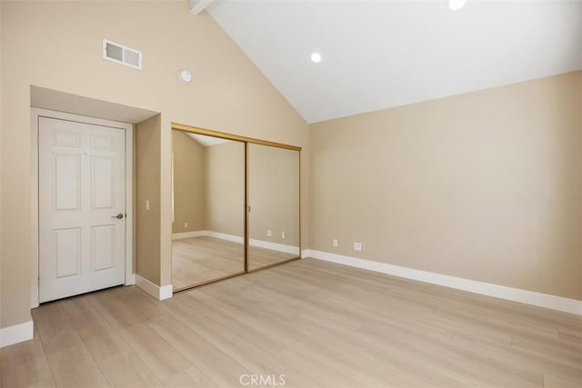 unfurnished bedroom featuring high vaulted ceiling, visible vents, light wood-type flooring, and baseboards