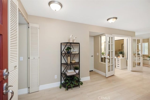 interior space with french doors, baseboards, and light wood finished floors