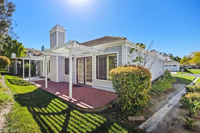 back of house with a yard, a patio area, and a pergola