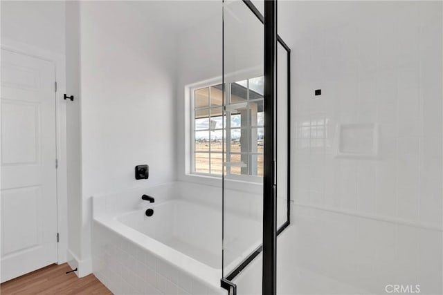 bathroom featuring a garden tub and wood finished floors