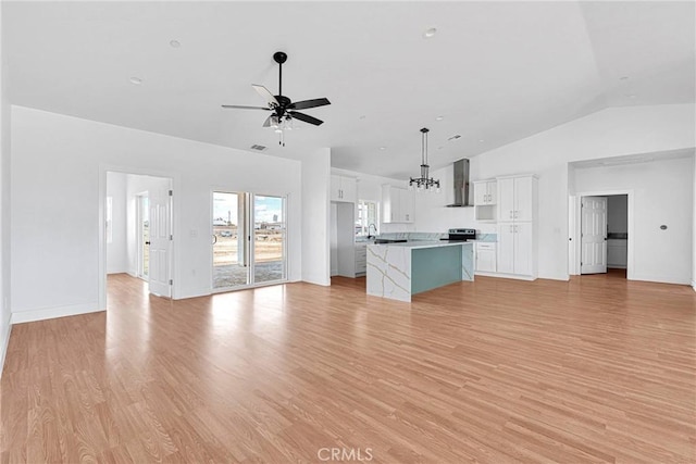 unfurnished living room featuring light wood-style flooring, vaulted ceiling, baseboards, and ceiling fan