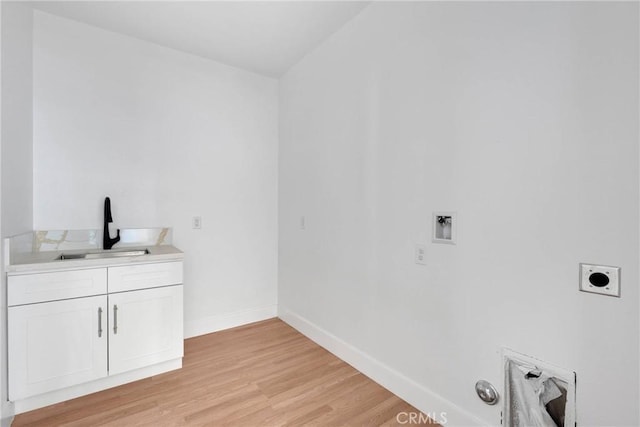 laundry room featuring baseboards, hookup for a washing machine, electric dryer hookup, light wood-style floors, and a sink