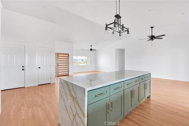 kitchen with green cabinets, open floor plan, light wood-type flooring, and lofted ceiling