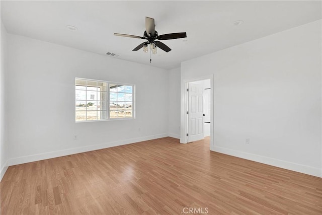 unfurnished room with a ceiling fan, baseboards, visible vents, and light wood finished floors