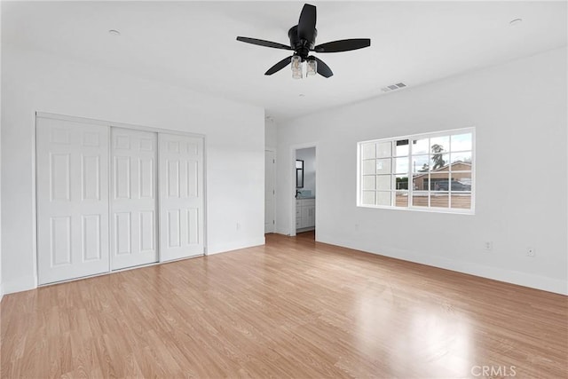 unfurnished bedroom with a closet, visible vents, light wood-style flooring, a ceiling fan, and baseboards