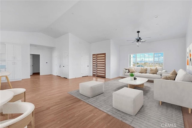 living area with a ceiling fan, lofted ceiling, and light wood finished floors