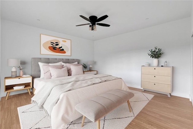 bedroom with a ceiling fan, light wood-style flooring, and baseboards