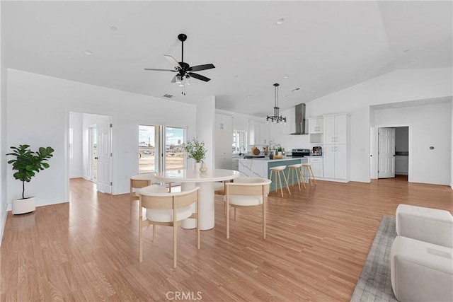 dining area featuring lofted ceiling, light wood-style flooring, and a ceiling fan