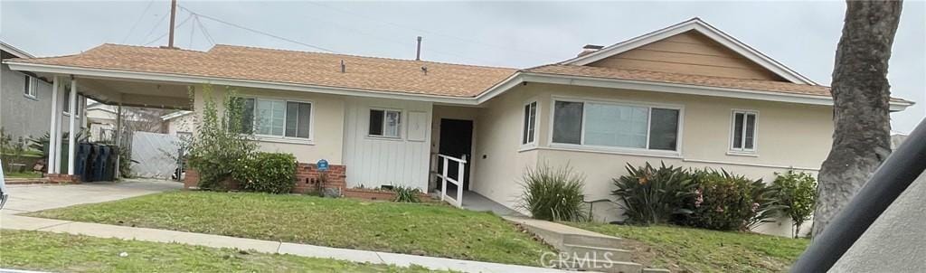 view of front of house with stucco siding and a front yard