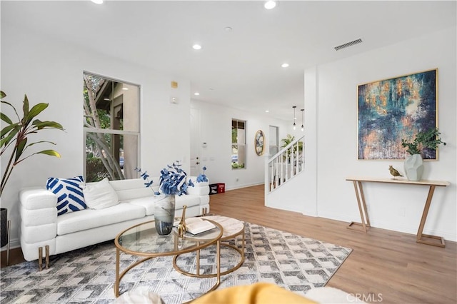 living area with stairway, recessed lighting, wood finished floors, and visible vents