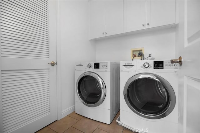 laundry room featuring tile patterned flooring, cabinet space, and separate washer and dryer