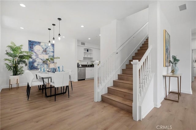 dining room with light wood-type flooring, visible vents, recessed lighting, and stairway