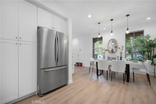 kitchen with recessed lighting, freestanding refrigerator, white cabinets, light wood-style floors, and pendant lighting