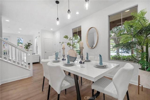 dining area featuring recessed lighting, stairs, and wood finished floors