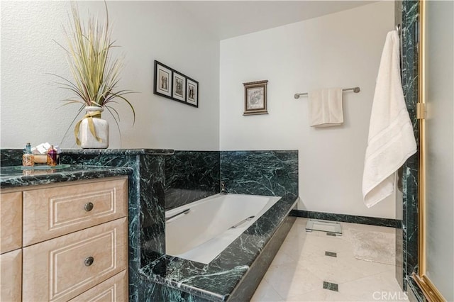 full bathroom with baseboards, a bath, and vanity