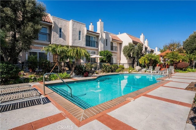 community pool featuring fence and a residential view
