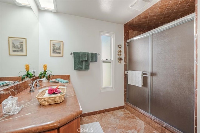 bathroom featuring a stall shower, tile patterned floors, vanity, and baseboards