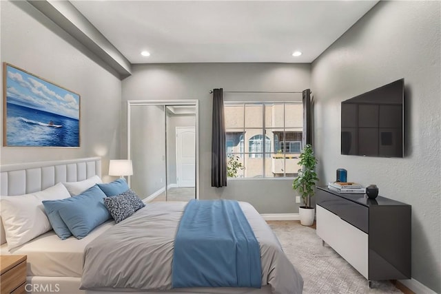 bedroom featuring recessed lighting, baseboards, a closet, and light colored carpet