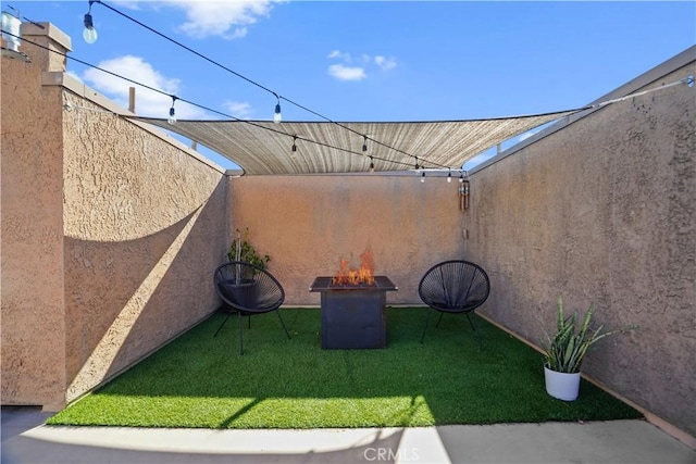 view of patio with an outdoor fire pit and fence