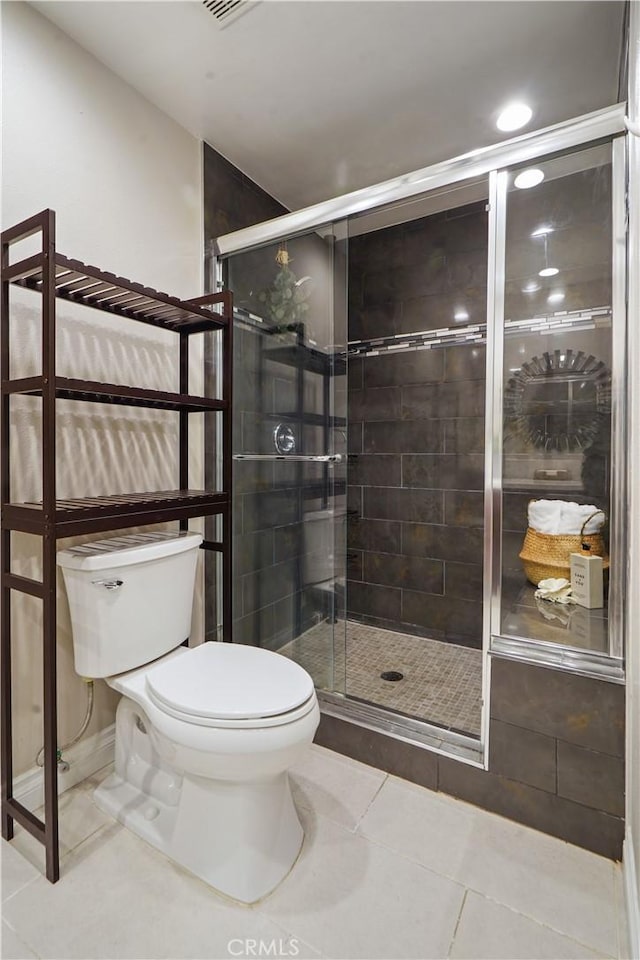 full bath with toilet, a stall shower, and tile patterned floors