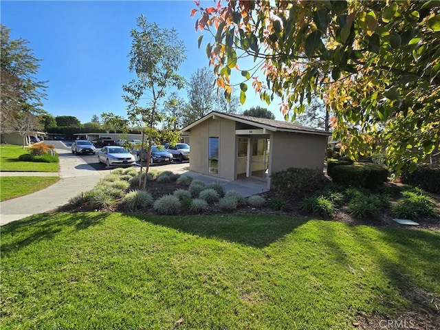 view of home's exterior featuring a yard, driveway, and stucco siding