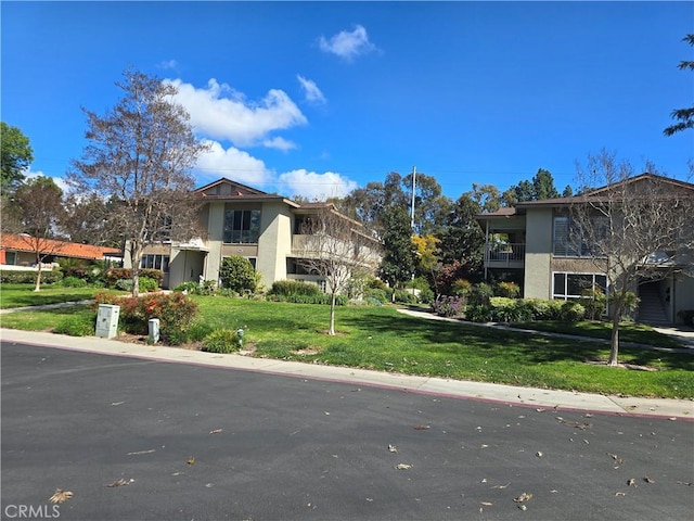 view of front facade with a front yard and stucco siding