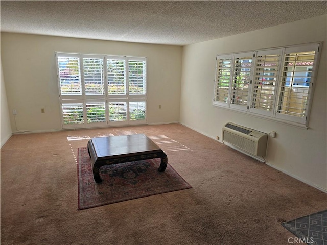 carpeted living room with baseboards, an AC wall unit, and a textured ceiling