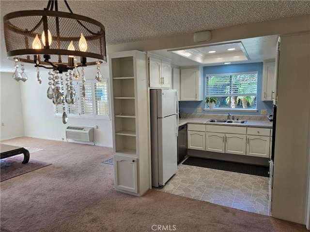 kitchen featuring freestanding refrigerator, a notable chandelier, a sink, and dark carpet