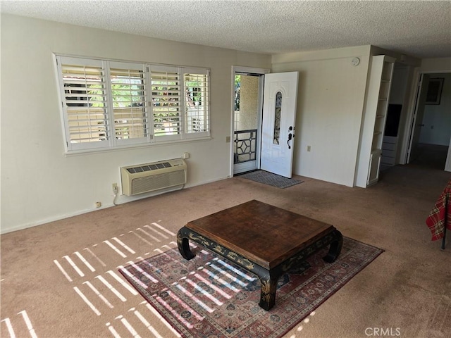 carpeted living area featuring a wall mounted air conditioner and a textured ceiling