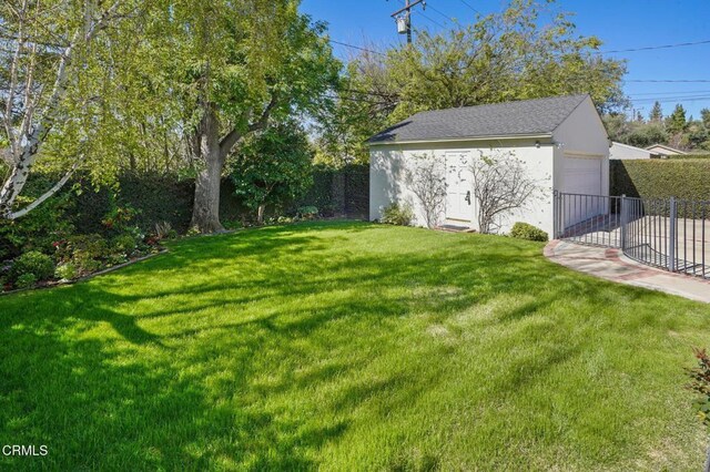 view of yard featuring an outbuilding, fence, and a garage