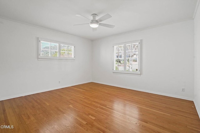 spare room with crown molding, wood finished floors, and baseboards