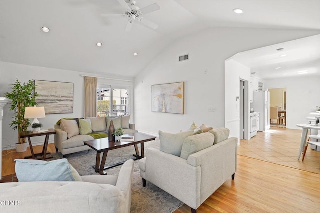 living area featuring a ceiling fan, visible vents, light wood-style flooring, recessed lighting, and vaulted ceiling