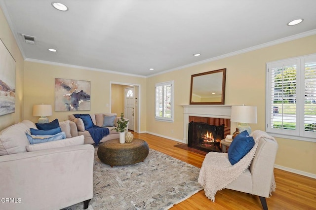 living area with wood finished floors, a fireplace, visible vents, and a wealth of natural light