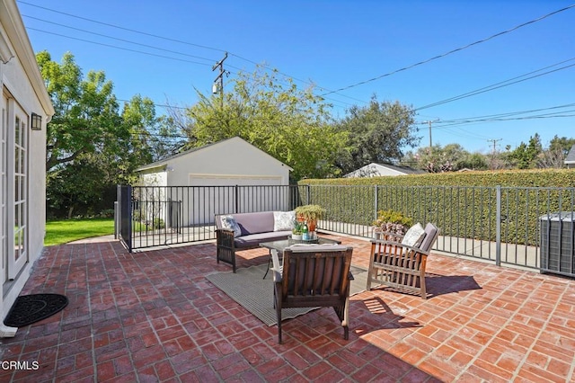 view of patio / terrace featuring an outbuilding, an outdoor living space, a detached garage, fence, and central AC unit