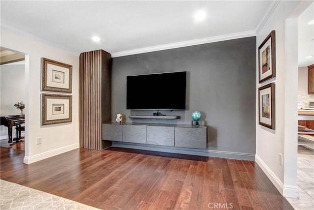 living area featuring ornamental molding, wood finished floors, and baseboards