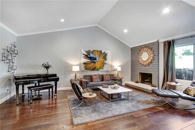 living area with lofted ceiling, ornamental molding, a brick fireplace, wood finished floors, and baseboards