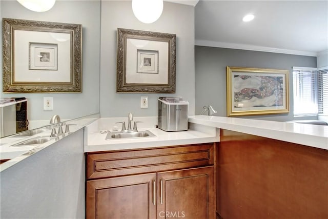 bathroom with crown molding and a sink