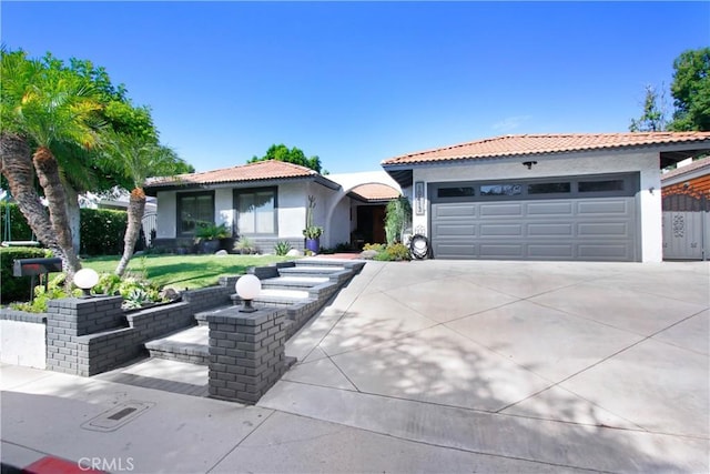 view of front of home with driveway, an attached garage, a tiled roof, and stucco siding