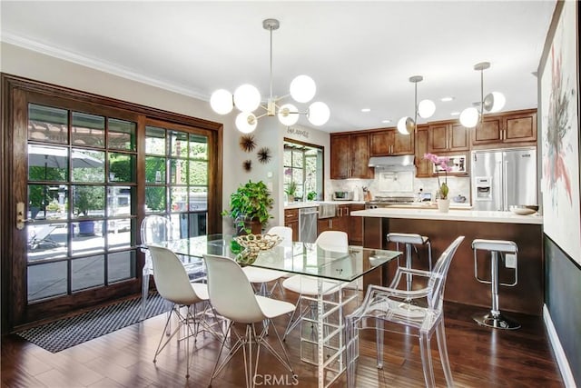 dining area featuring dark wood-style flooring and crown molding