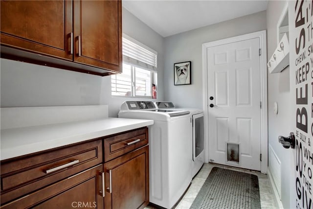 laundry room with washing machine and clothes dryer and cabinet space